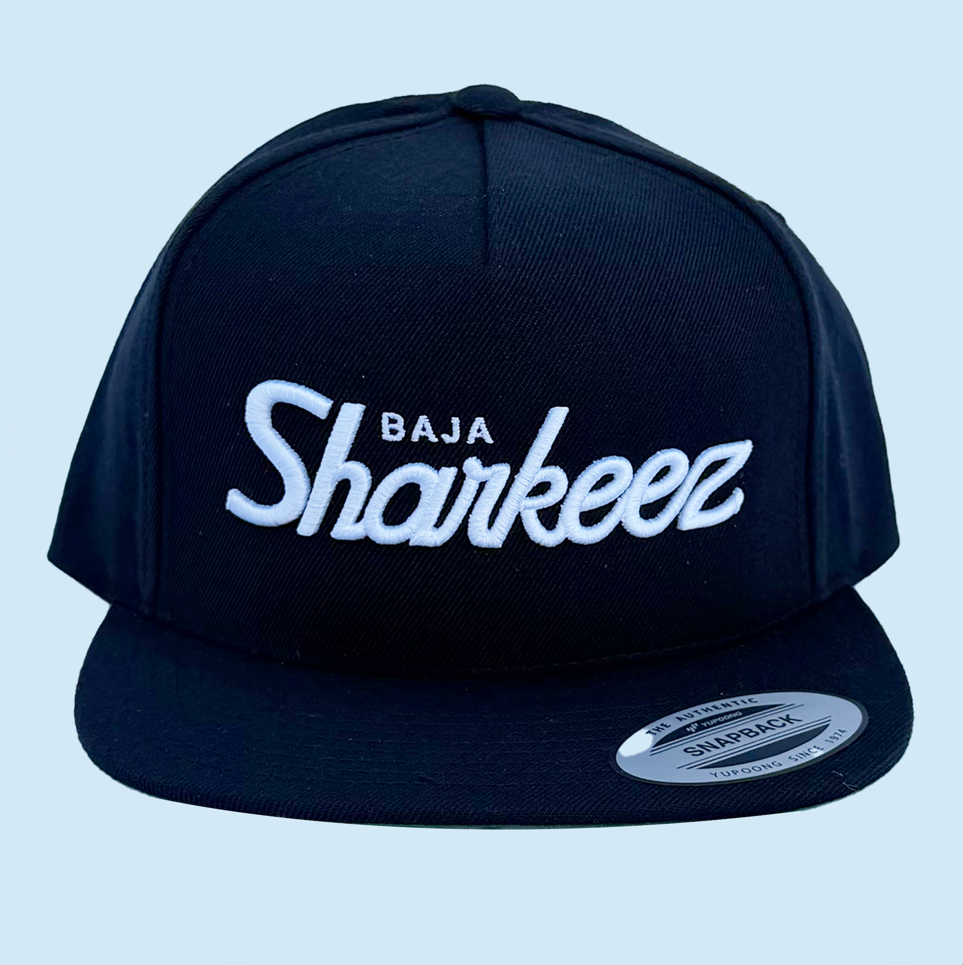 Black cap with 'Baja Sharkeez' text on a light blue background
