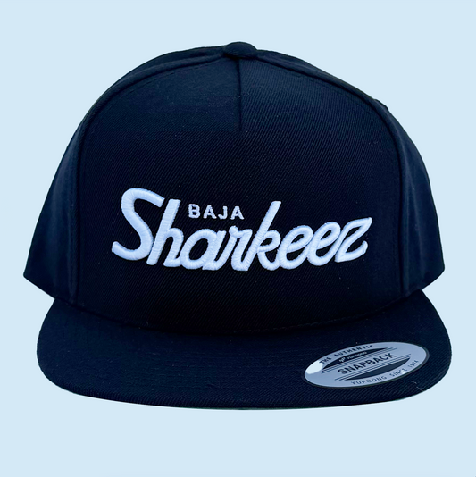 Black cap with 'Baja Sharkeez' text on a light blue background